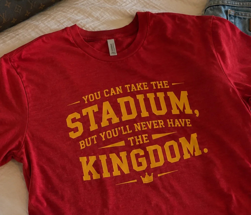 Close-up of the gold Kingdom message printed on the red tee